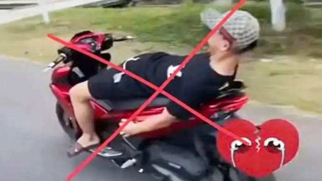 Không đội mũ bảo hiểm, buông cả 2 tay nằm dài trên yên khi lái xe máy trên đường