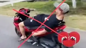 Không đội mũ bảo hiểm, buông cả 2 tay nằm dài trên yên khi lái xe máy trên đường